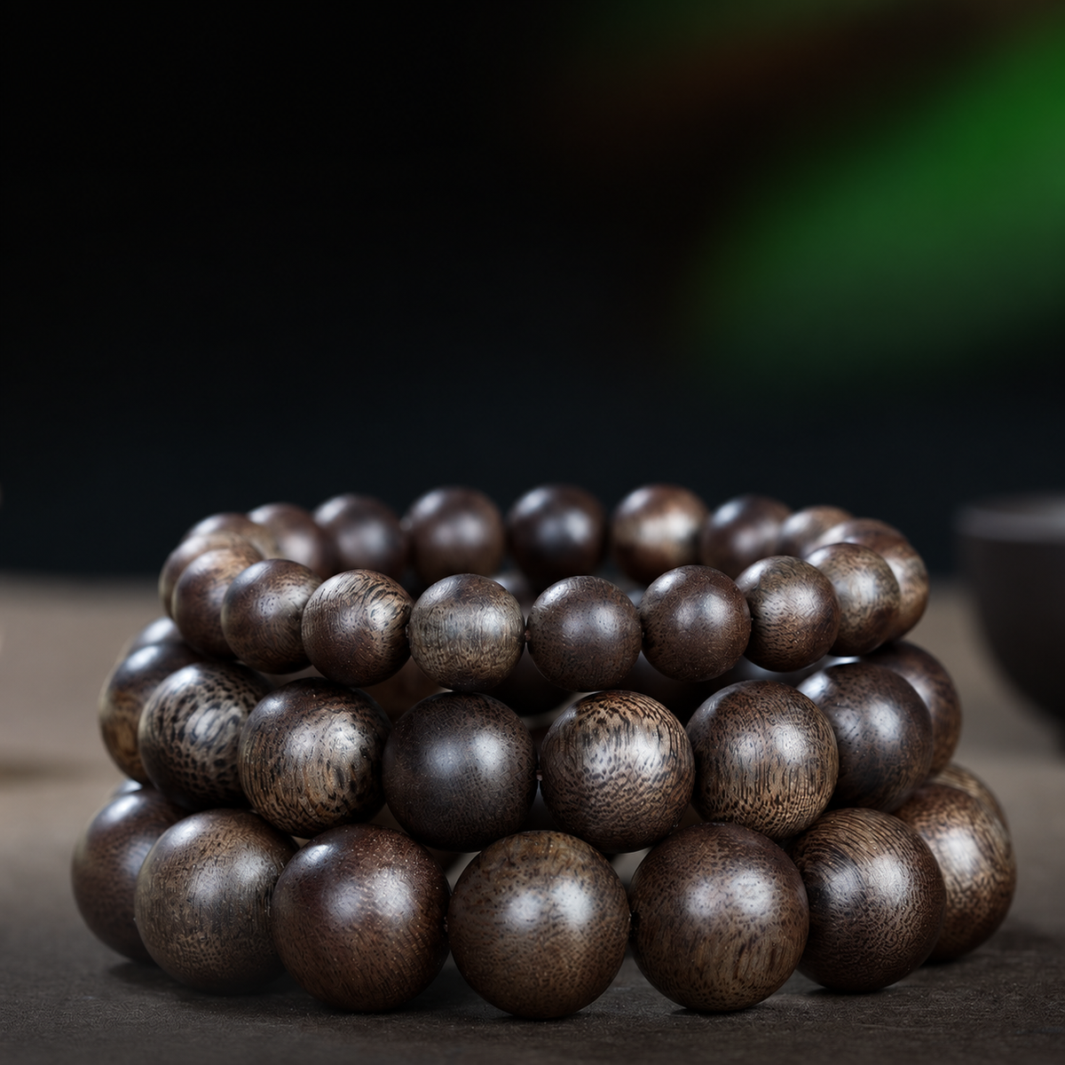 Three dark brown wood bracelets showing different bead sizes, illustrative size comparison