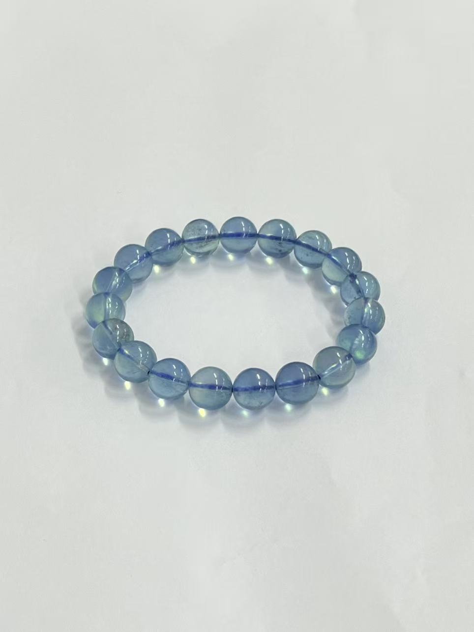 Aquamarine bracelet showing bead translucence and blue cord