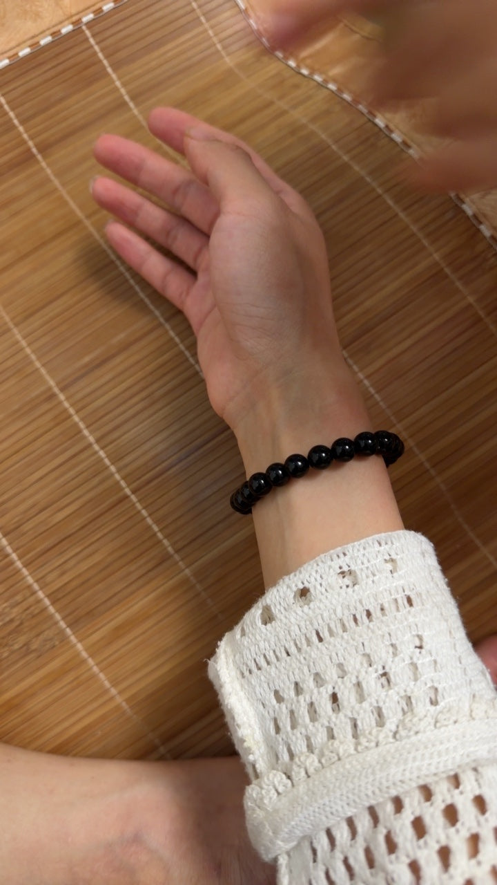 Black obsidian bracelet worn on a wrist