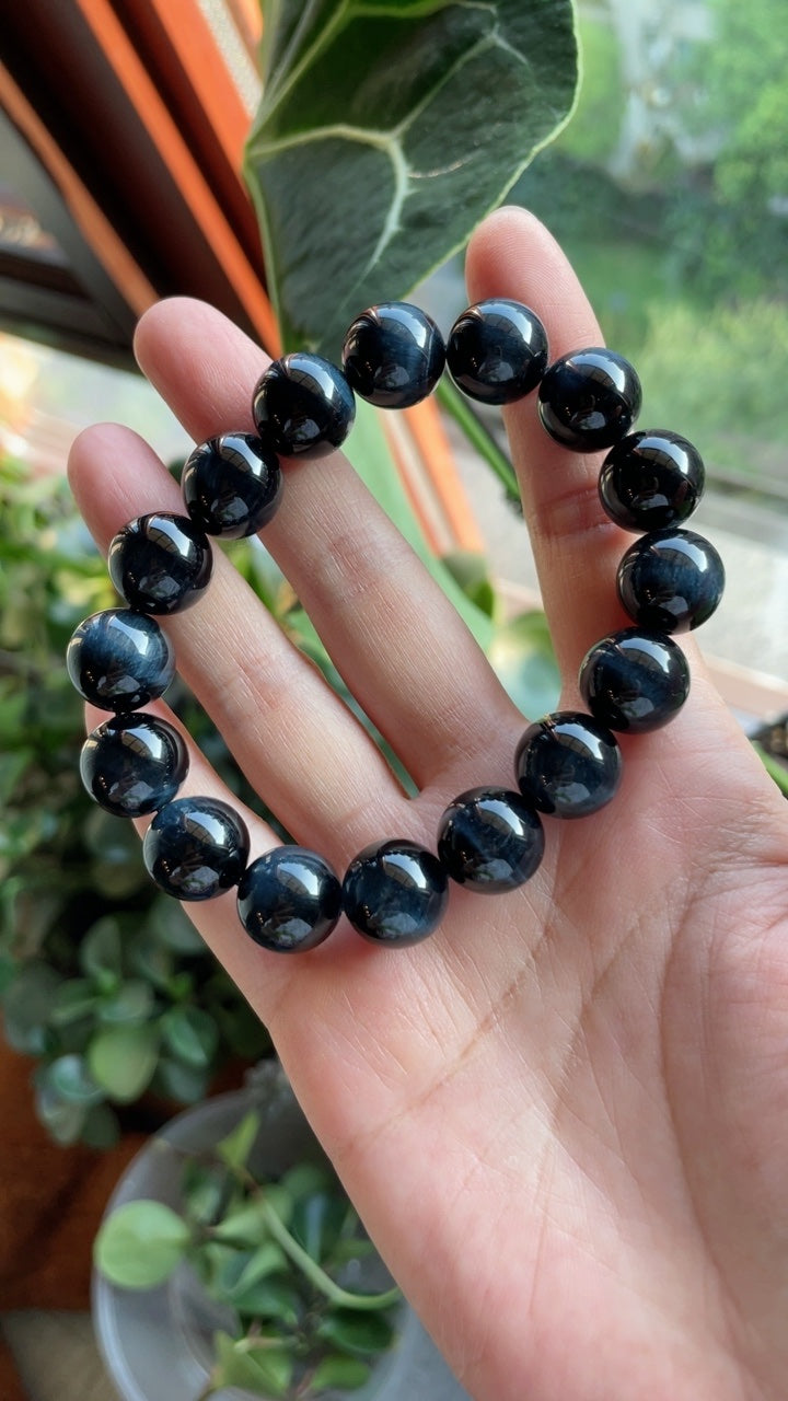 Blue tiger eye single-strand bracelet photographed in hand