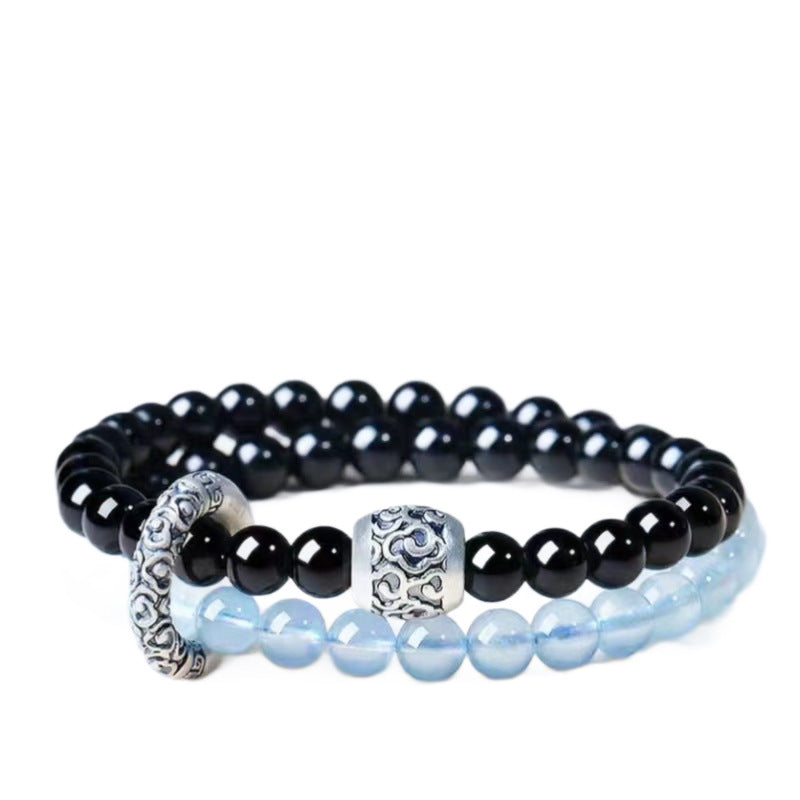 Double-wrap bracelet showing black and icy blue beads with ornate cloud-pattern accents