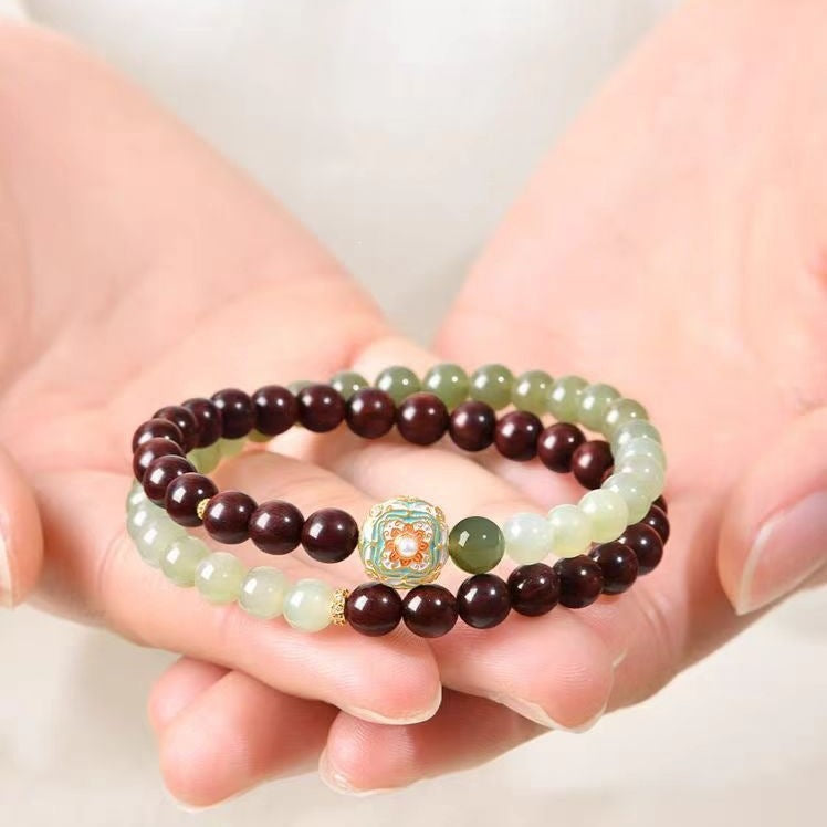 Red sandalwood and Hetian jade bracelet held for scale