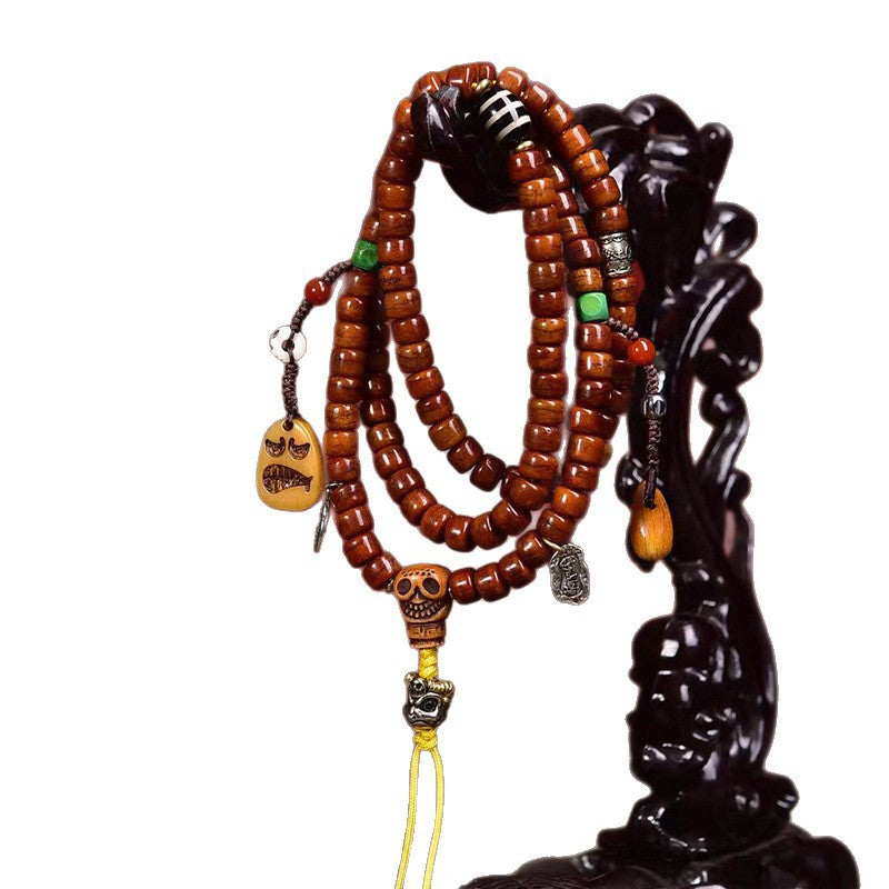 Decorative yak bone mala with skull accents on a display stand