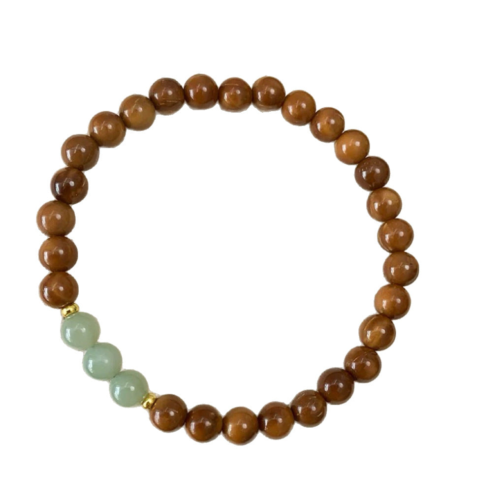 Brown seed beads and three pale green jade accents on white