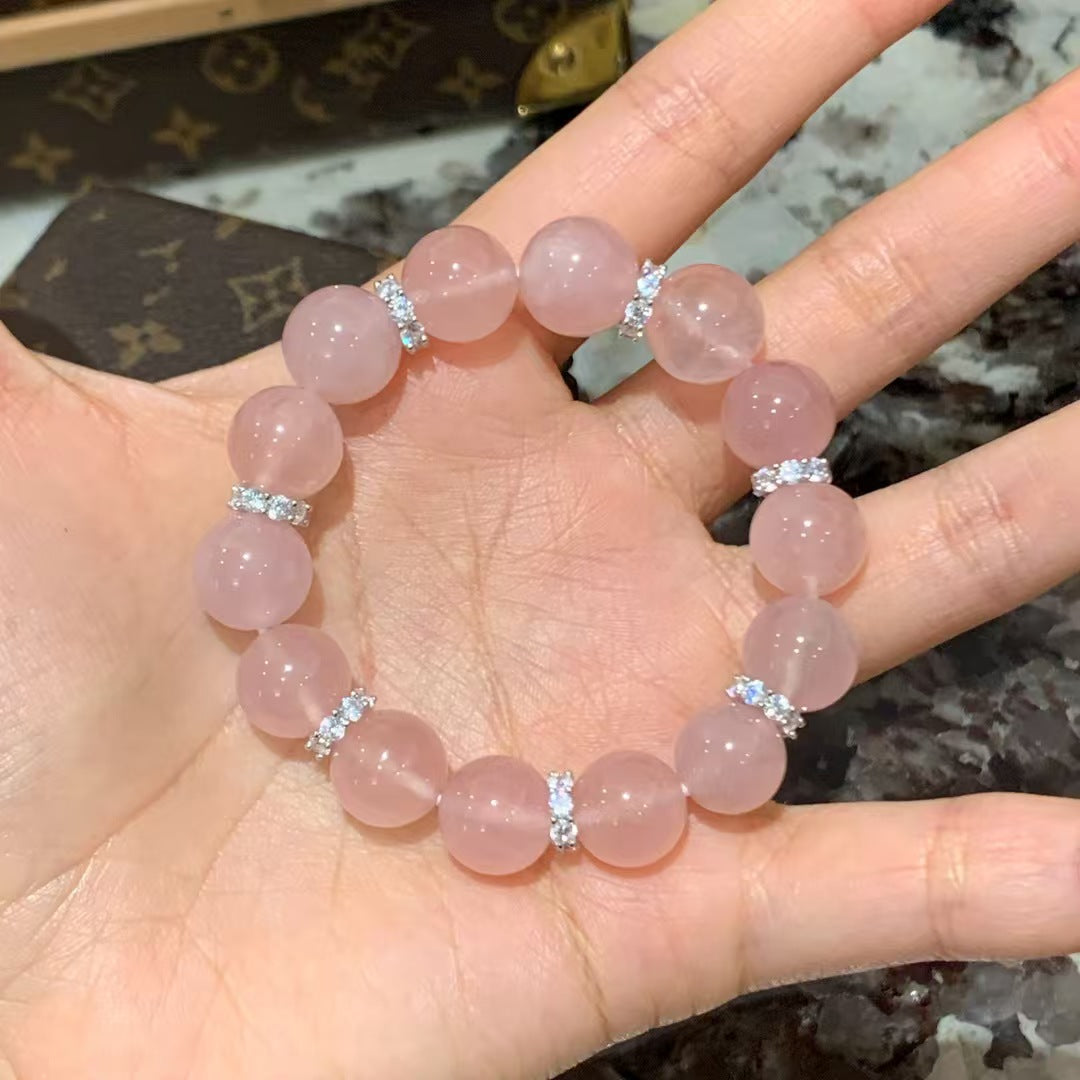 Blush pink rose quartz bracelet shown on palm in the accurate source photo