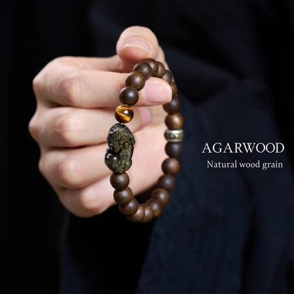 Agarwood bracelet held to show natural wood grain