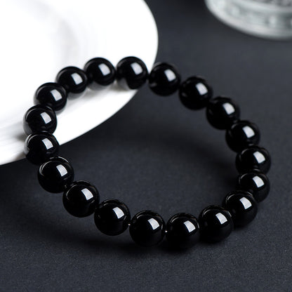 Black obsidian bracelet on a dark tabletop