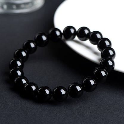 Angled view of polished black obsidian beads