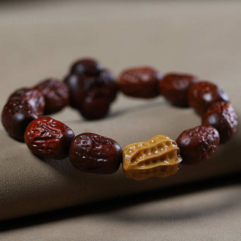 Low-angle view of carved red-brown wood beads and yellow peanut accent