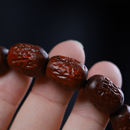 Close view of carved red sandalwood grain and recessed decorative marks