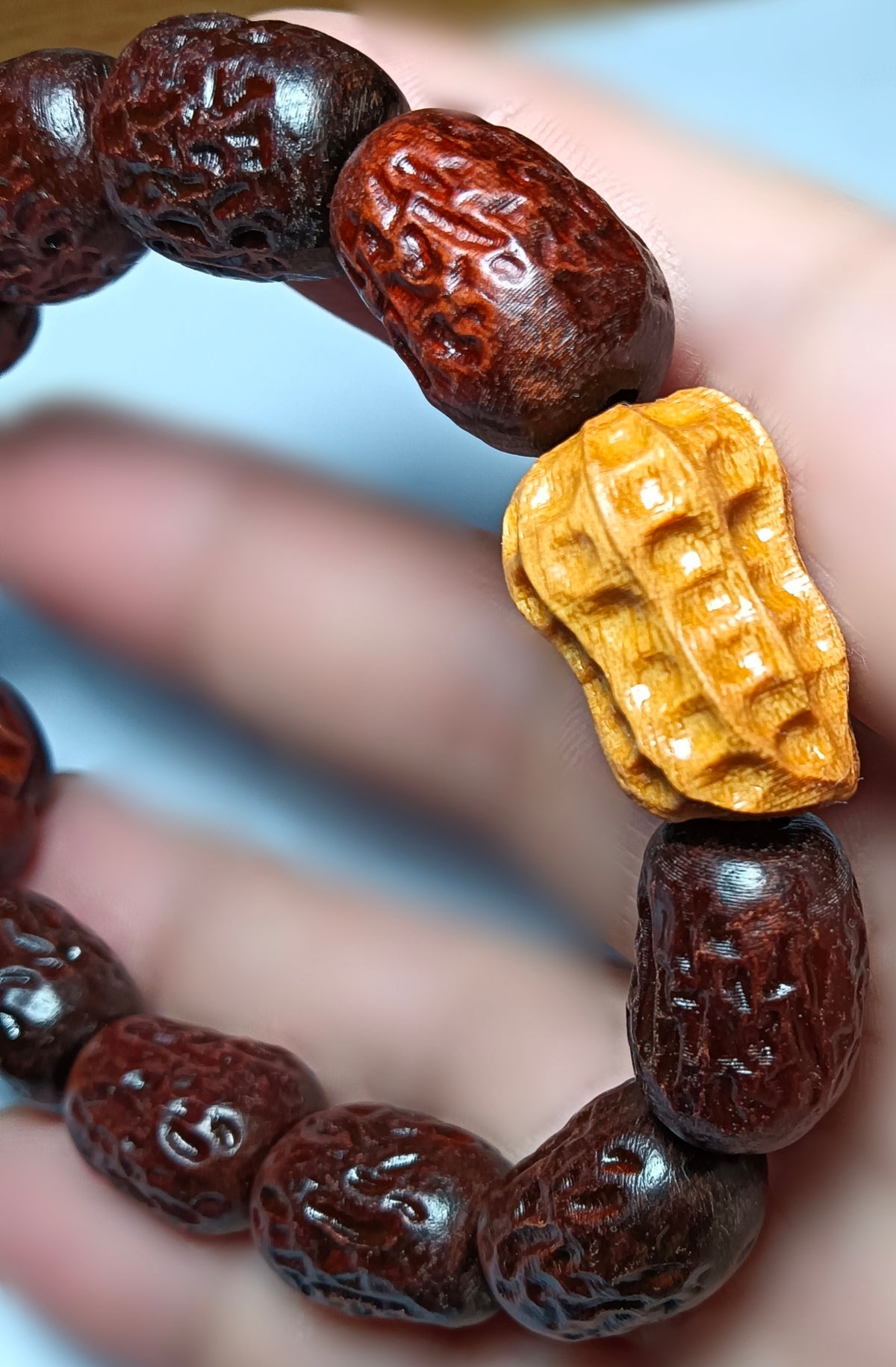 Close view of the yellow peanut-shaped accent and carved wood beads