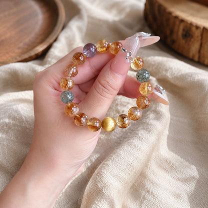 Natural citrine, yellow rutilated quartz and golden tiger eye bracelet held in hand