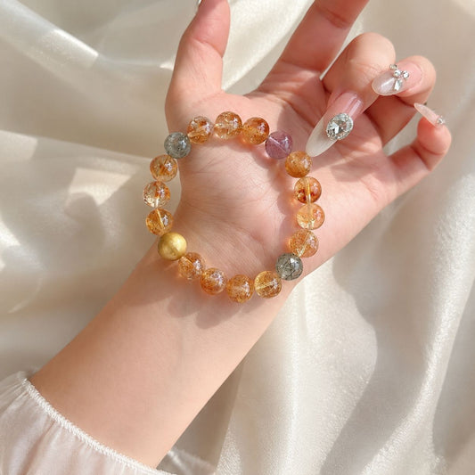 Natural mixed crystal and golden tiger eye bracelet shown on palm