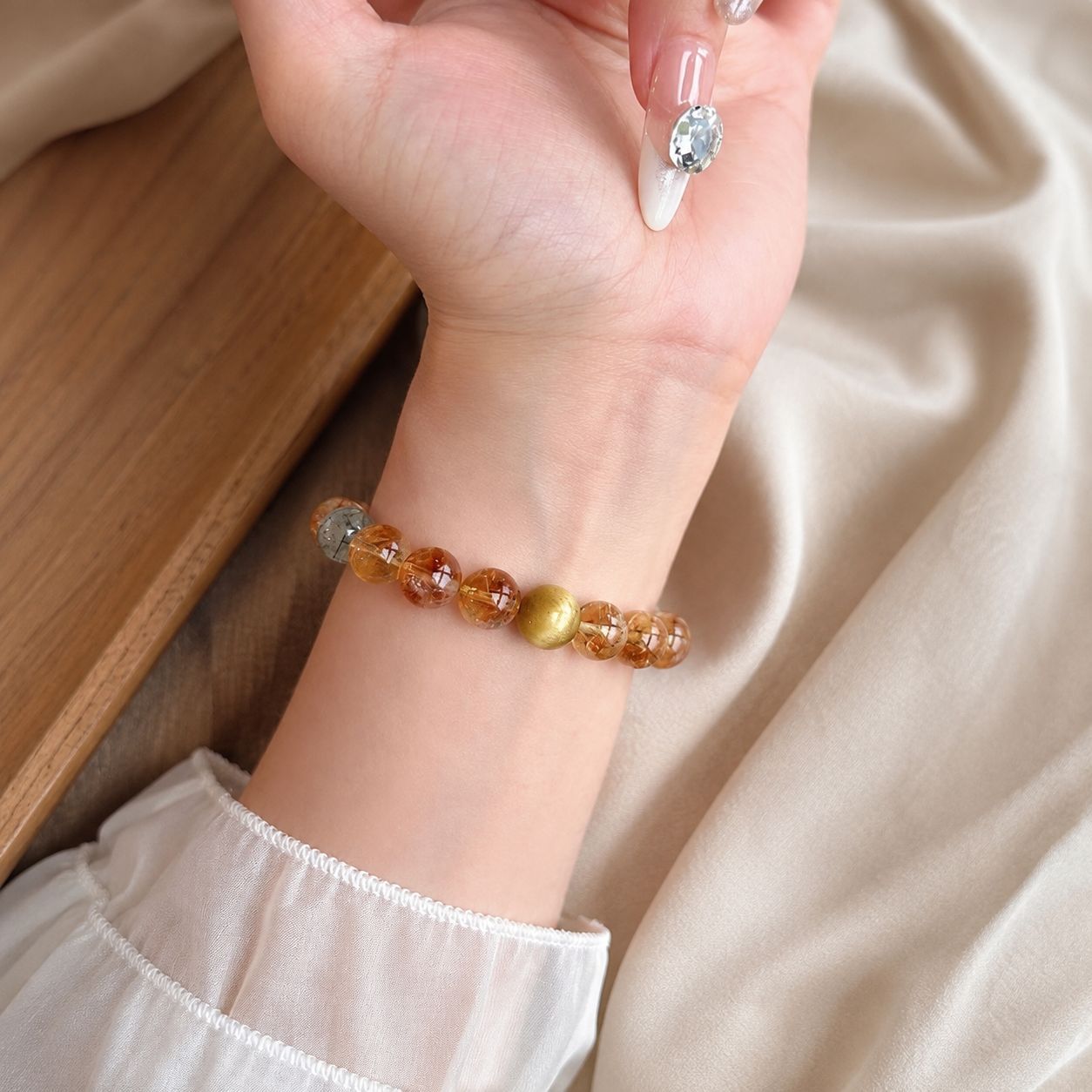 Natural golden rutilated quartz and tiger eye bracelet wrist detail