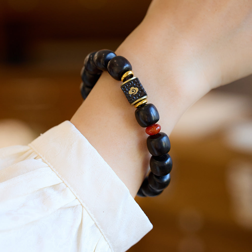Cloud-motif centerpiece and gold-tone spacers on an ebony bracelet