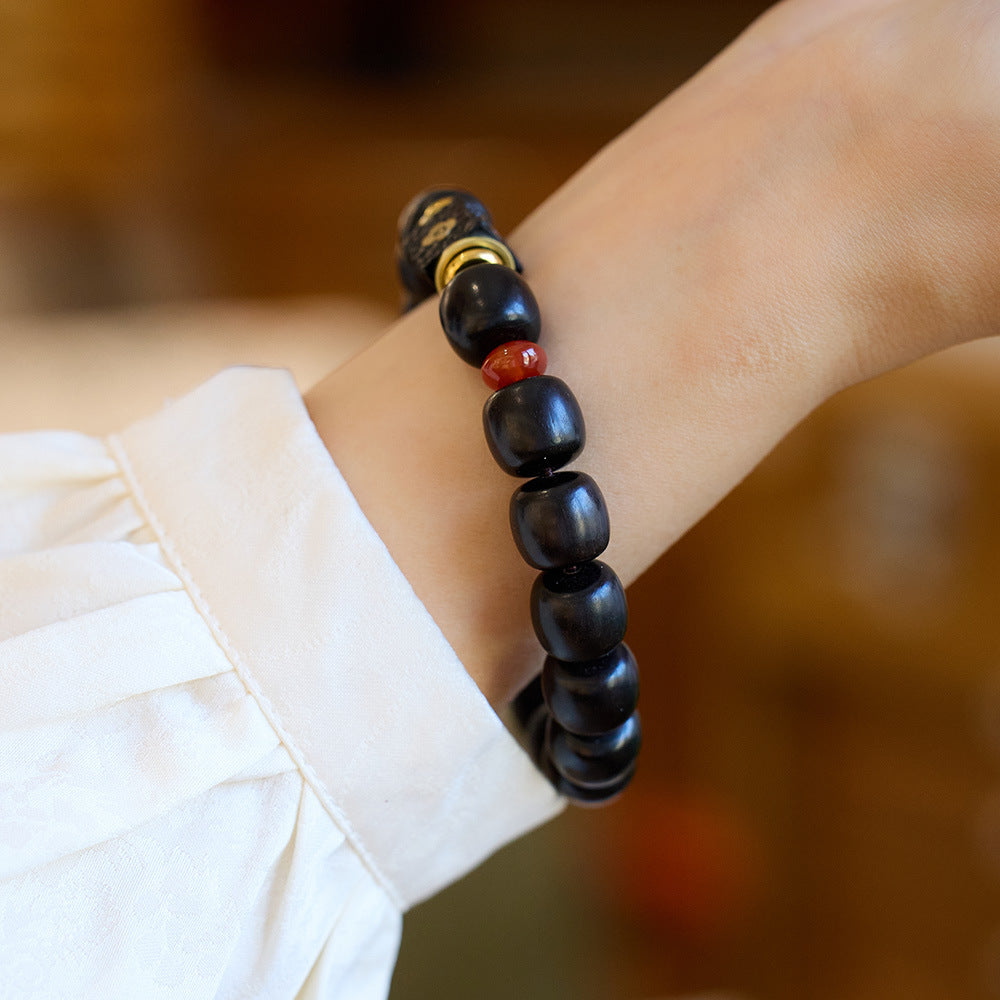 Dark ebony barrel beads worn on a wrist