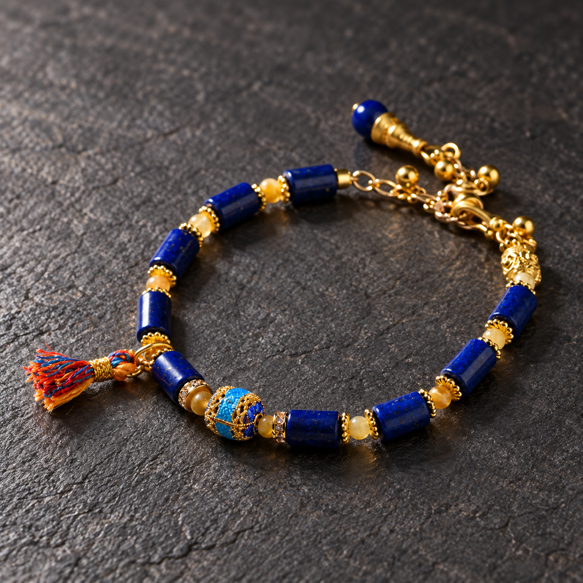 Blue and gold tassel bracelet on dark stone