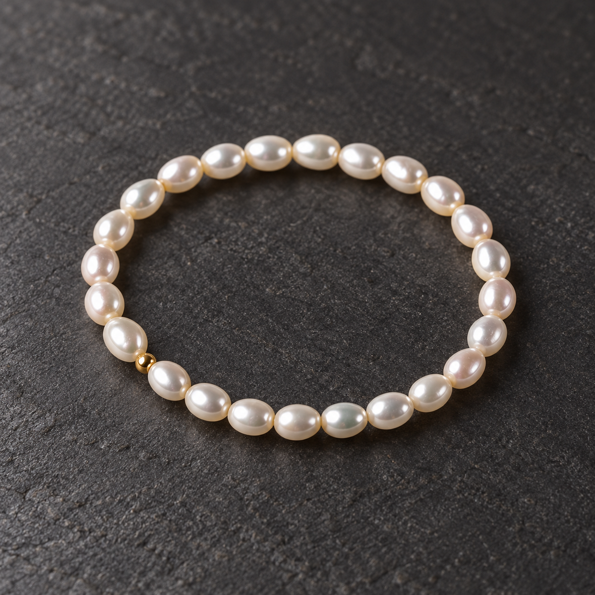 Freshwater teardrop pearl bracelet on a dark textured surface