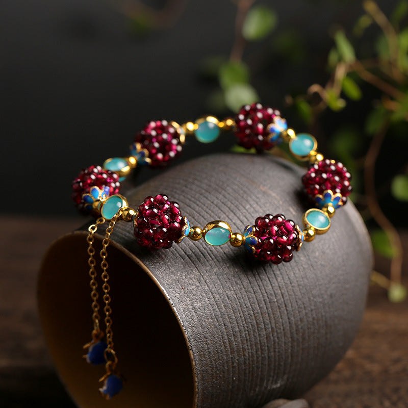 Amazonite garnet cluster bracelet displayed on a dark stand