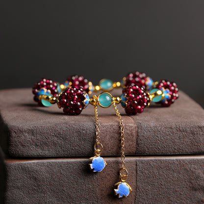 Close view of garnet clusters and two blue enamel dangling accents