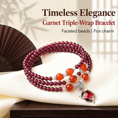 Faceted wine-red garnet triple-wrap bracelet with fox charm on cream fabric