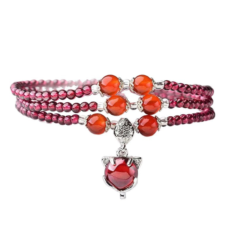 Garnet triple-wrap bracelet with fox charm on white background
