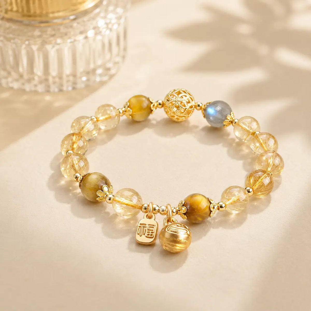 Golden Rutilated Quartz, Tiger Eye & Moonstone Bracelet – diagonal glass-bottle still life