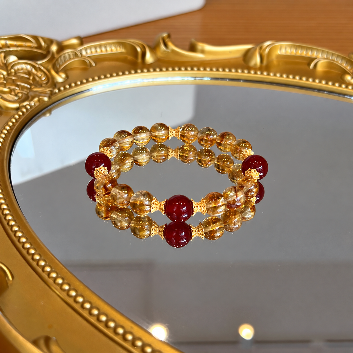 Classic golden quartz and red agate bracelet on a gold-framed mirror