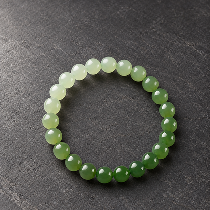 Gradient Hetian jade bracelet on a dark tabletop