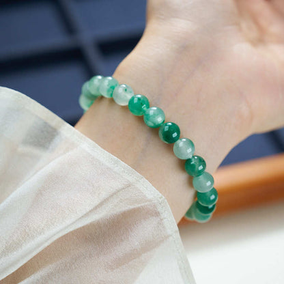 Plain 8mm green stone bracelet worn on a wrist