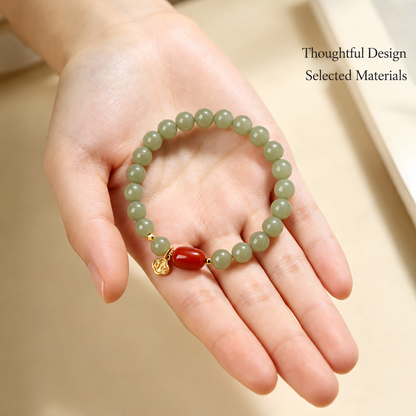 Jade and red agate bracelet shown in a hand