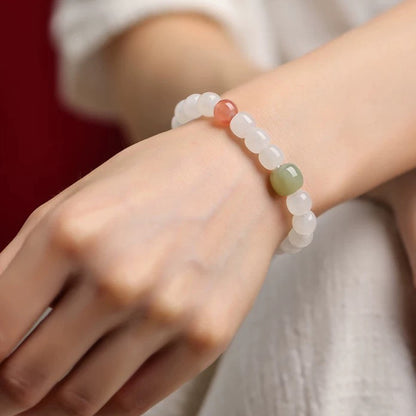 Orange and green accent Hetian jade bracelet worn on a wrist