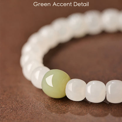 Green accent bead and white barrel bead close-up