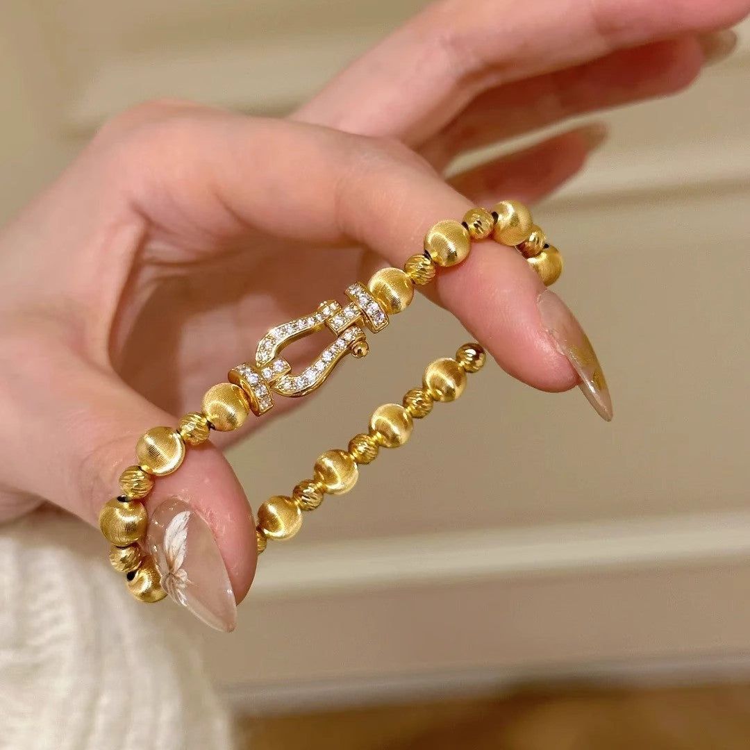 Gold-tone textured bead bracelet with horseshoe centerpiece