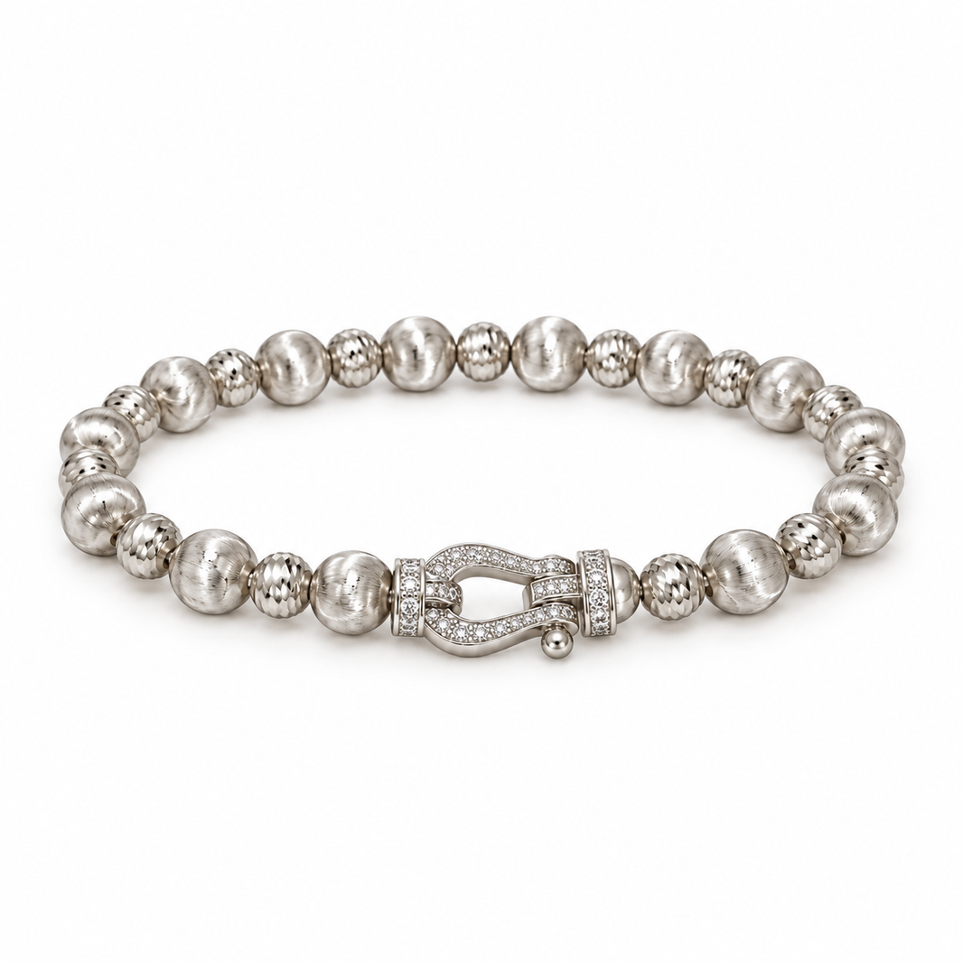Silver-tone textured bead bracelet with horseshoe accent on white
