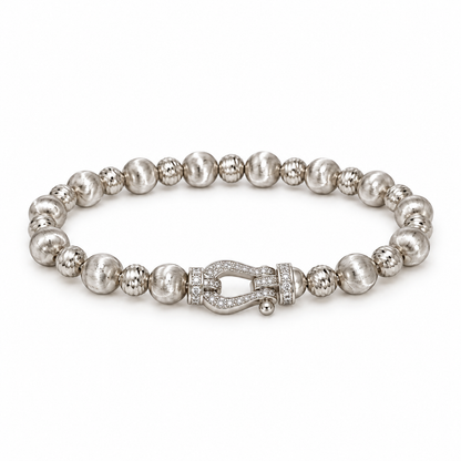 Silver-tone textured bead bracelet with horseshoe accent on white