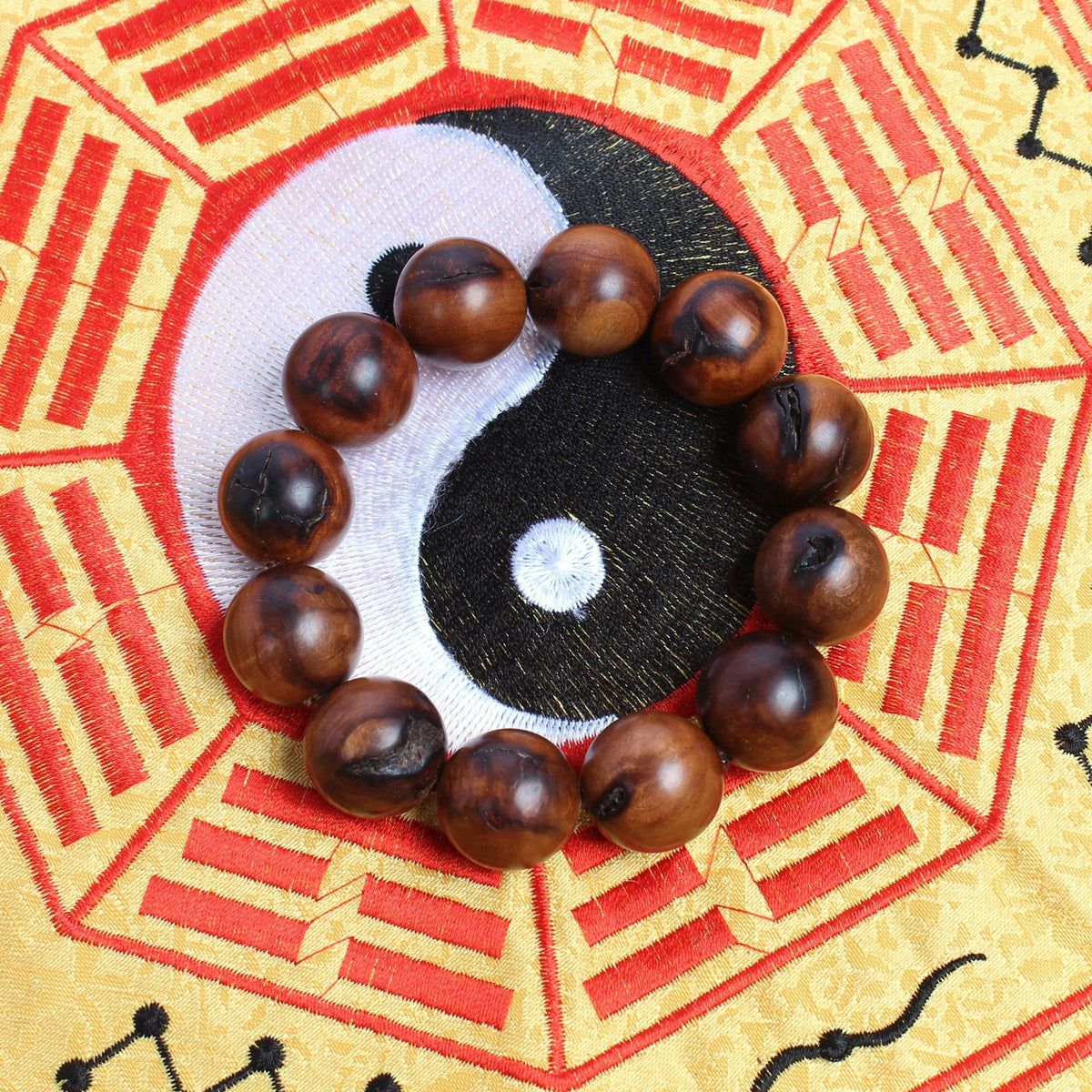 Twelve-bead jujube wood bracelet on a patterned textile