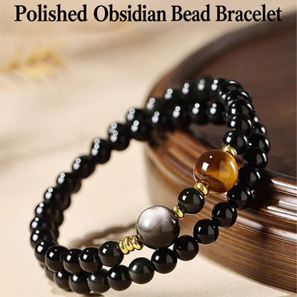 Angled view of obsidian bracelet with gold-tone spacers