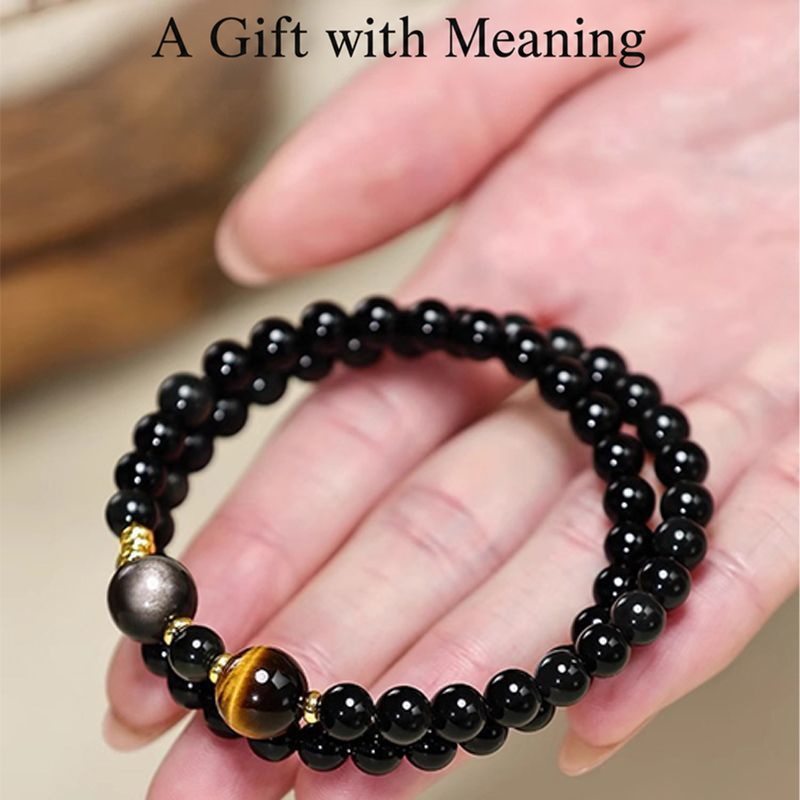 Obsidian and tiger eye double-wrap bracelet held in a hand