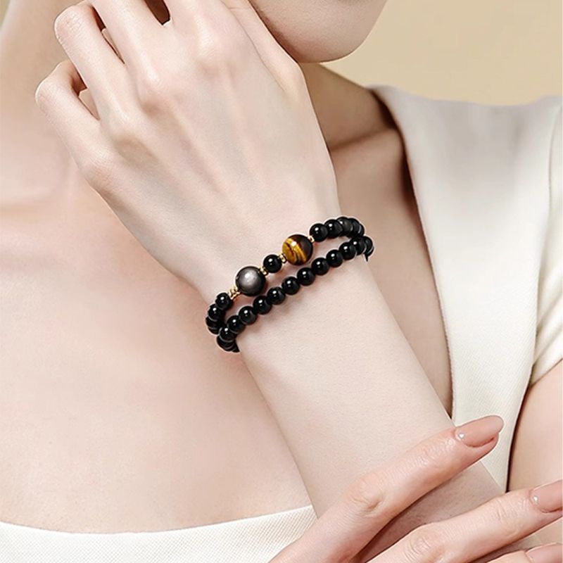 Obsidian and tiger eye double-wrap bracelet worn on the wrist