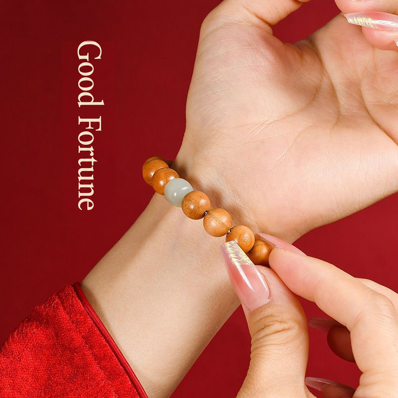 Peach wood bracelet worn on a wrist