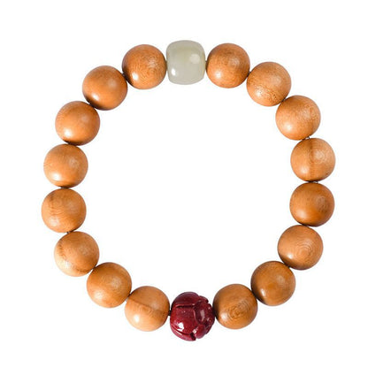 Overhead view of the original peach wood lotus bracelet on white