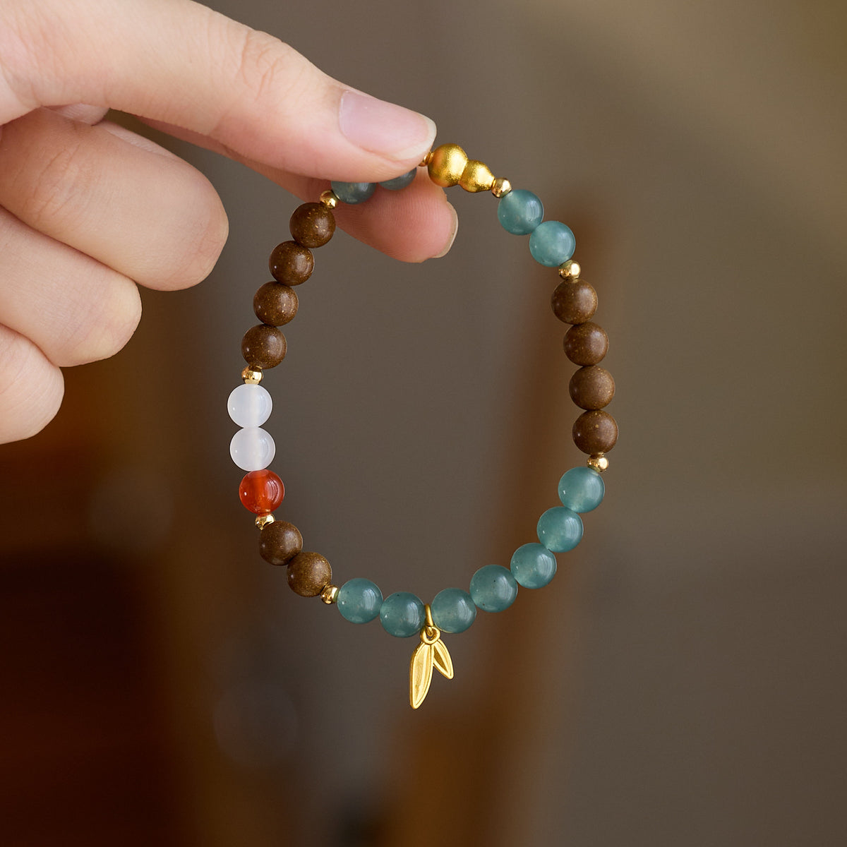 Close-up of the bracelet and gold-tone gourd bead
