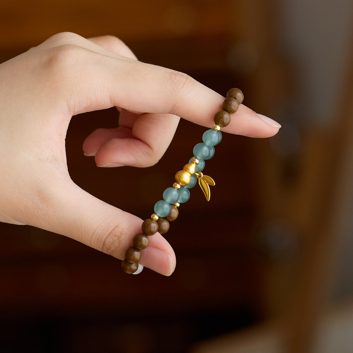 Gold-tone gourd and leaf details of the herbal incense bracelet