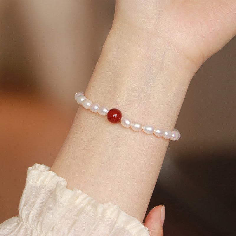 Freshwater pearl and red agate bracelet worn on a wrist