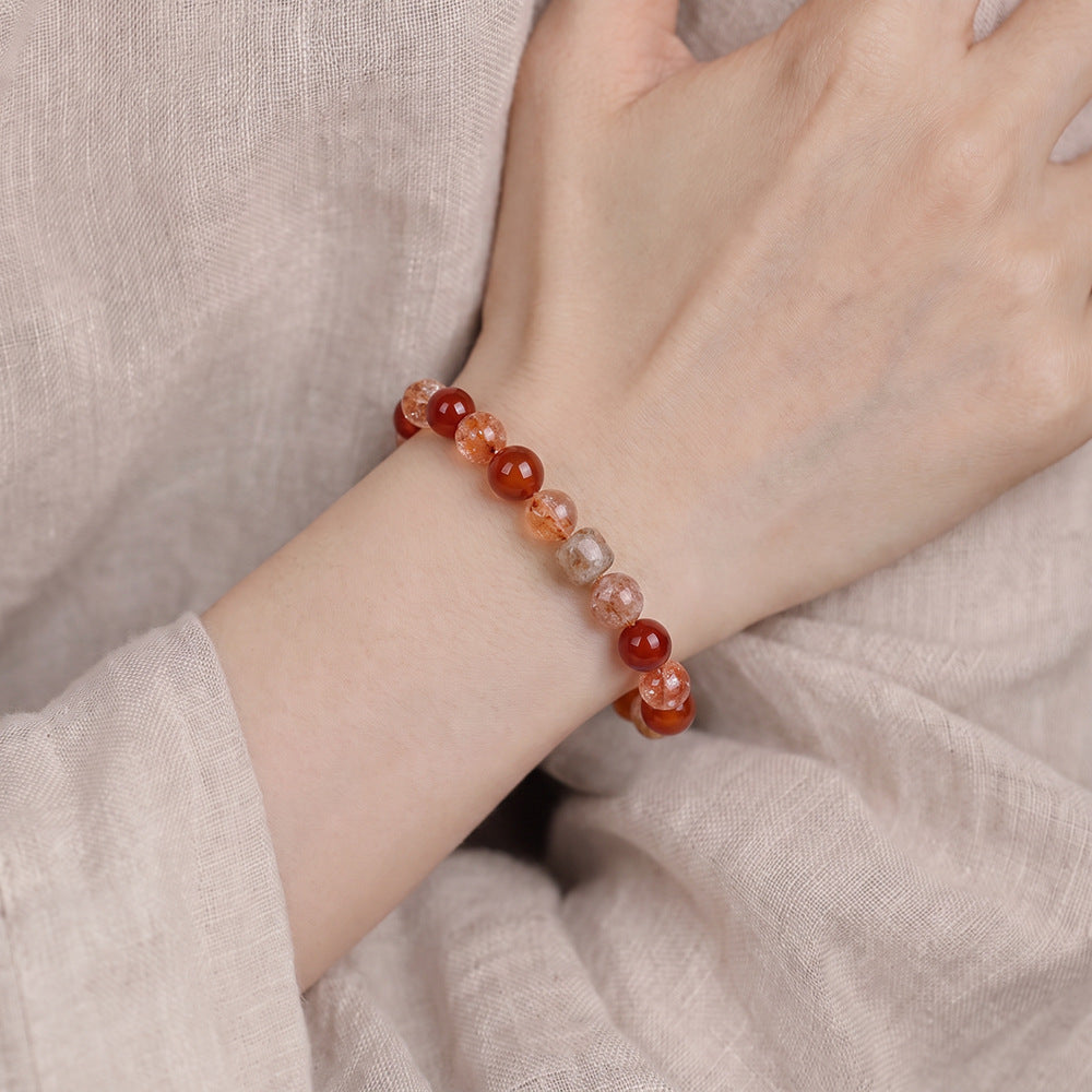 Red agate and quartz bracelet worn on a wrist