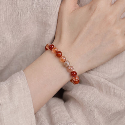 Red agate and quartz bracelet worn on a wrist