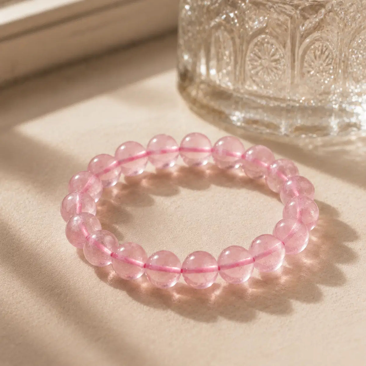 Natural Rose Quartz Bracelet – Pink Cord – diagonal glass-bottle still life