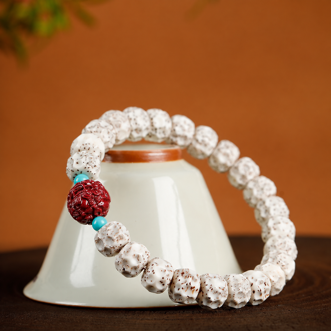Single star and moon bodhi bracelet displayed around a ceramic bowl, showing textured white beads and red Pixiu accent