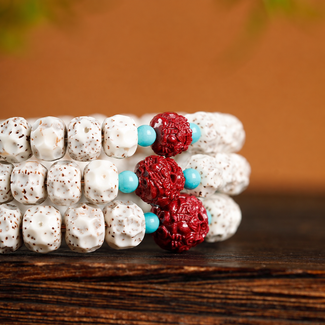 Close view of cream-white speckled bodhi beads, red carved Pixiu accents and blue-green spacers, shown stacked for detail